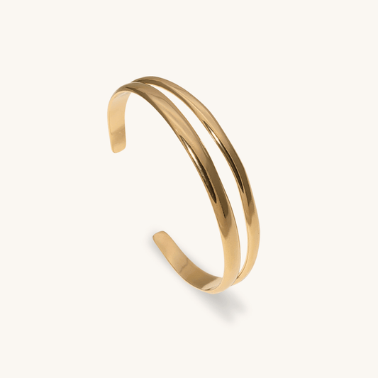 Bracciale rigido Succu oro 18k waterproof design doppio filo organico su sfondo crema Unique et Spécial