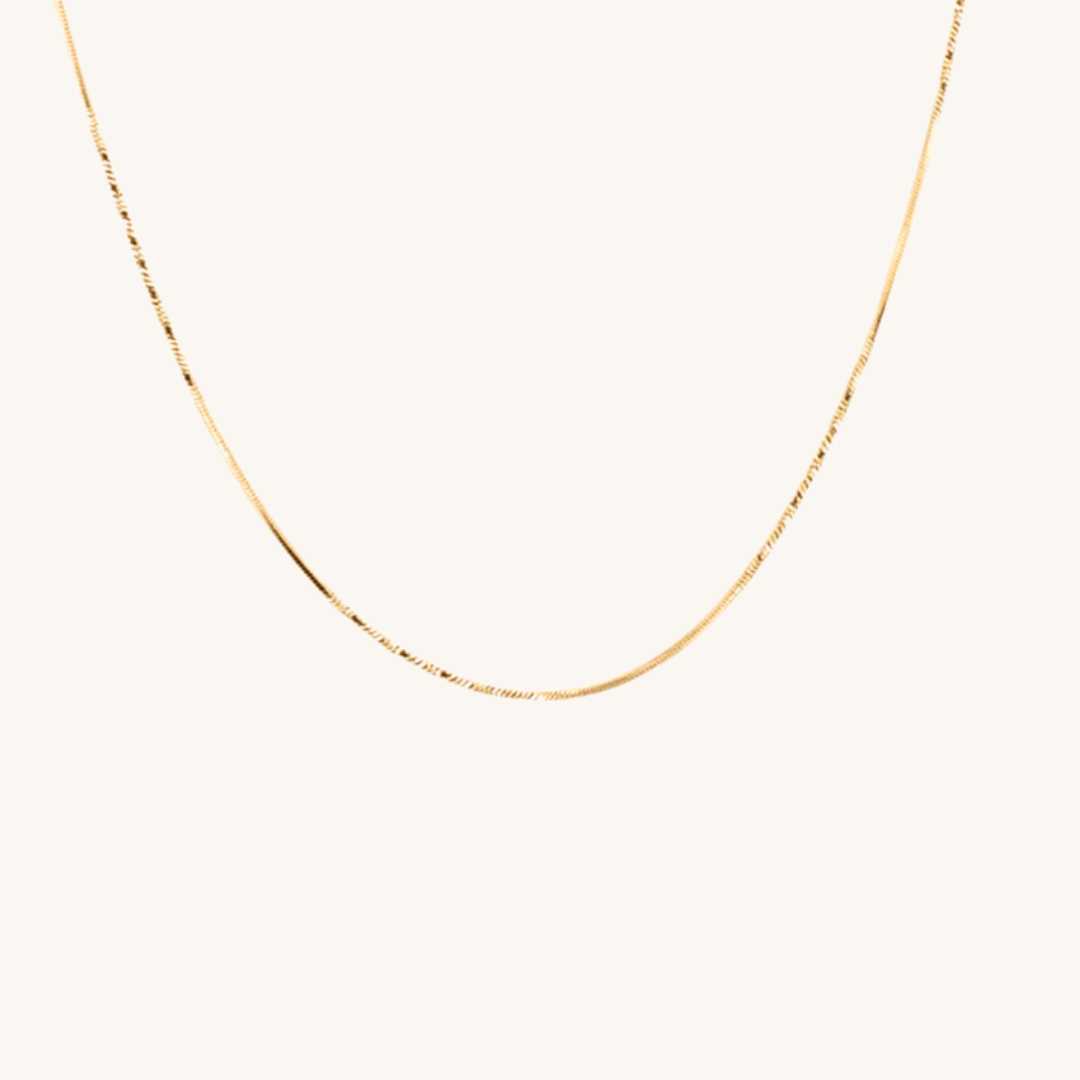 Collana piatta sottile oro 18k waterproof maglia silk touch indossata da modella Unique et Spécial