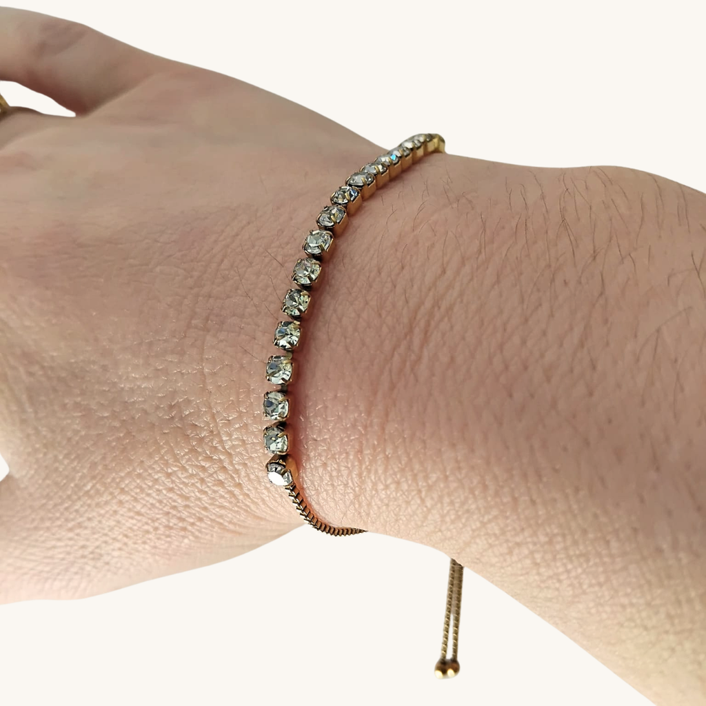 Bracciale tennis oro giallo con zirconi trasparenti, dettaglio fascia sul polso