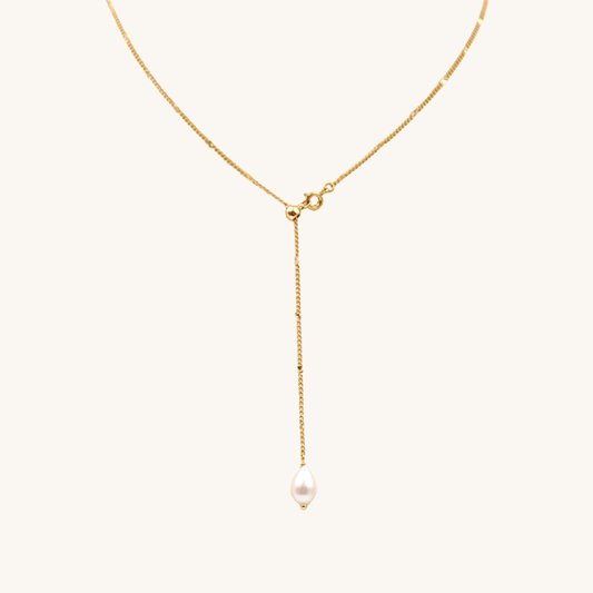 Collana a Y oro 18k waterproof con pendente perla a goccia su sfondo crema Unique et Spécial