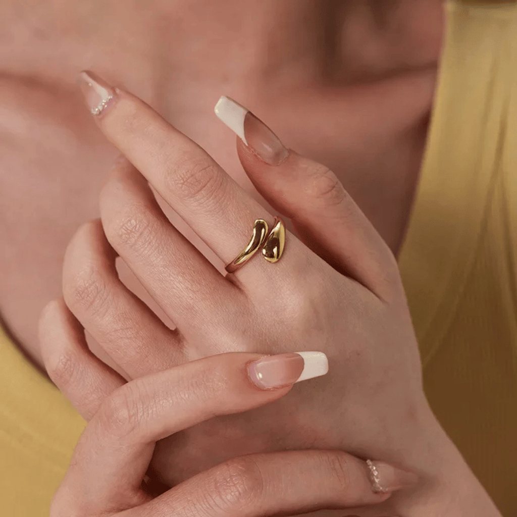 Anello oro 18 carati su dito, fascia lucida con dettaglio a nodo.