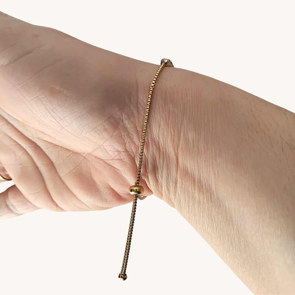 Bracciale tennis in oro giallo con zirconi trasparenti sul polso, chiusura a sfera