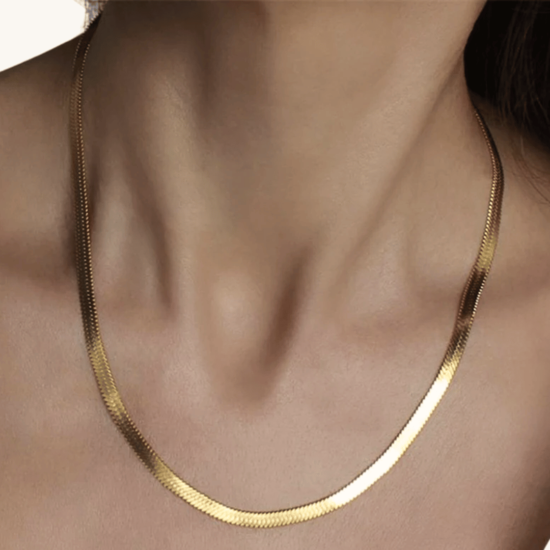 Collana oro 18 carati a catena sottile, indossata al collo con riflessi lucidi