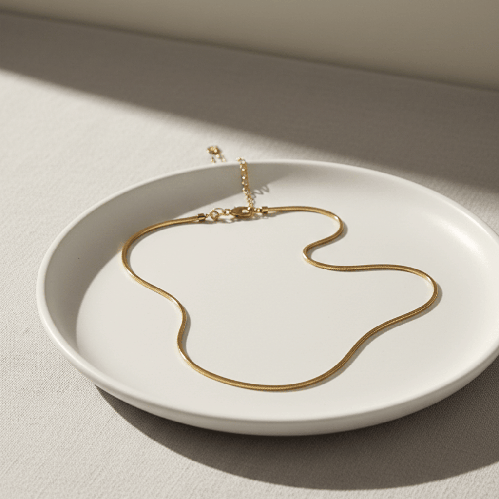 Collana in oro 18k a catena sottile ad andamento ondulato su piattino