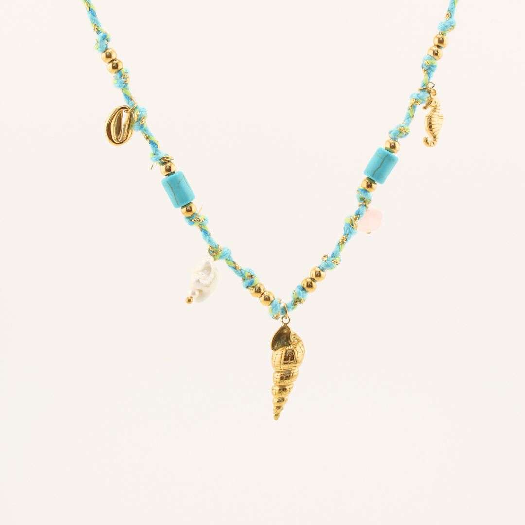 Collana in perline turchesi con ciondolo conchiglia dorato e charms pendenti.