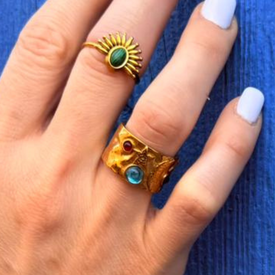 Anello oro con fascia a rilievo e pietre turchesi, verdi e rosse su dita