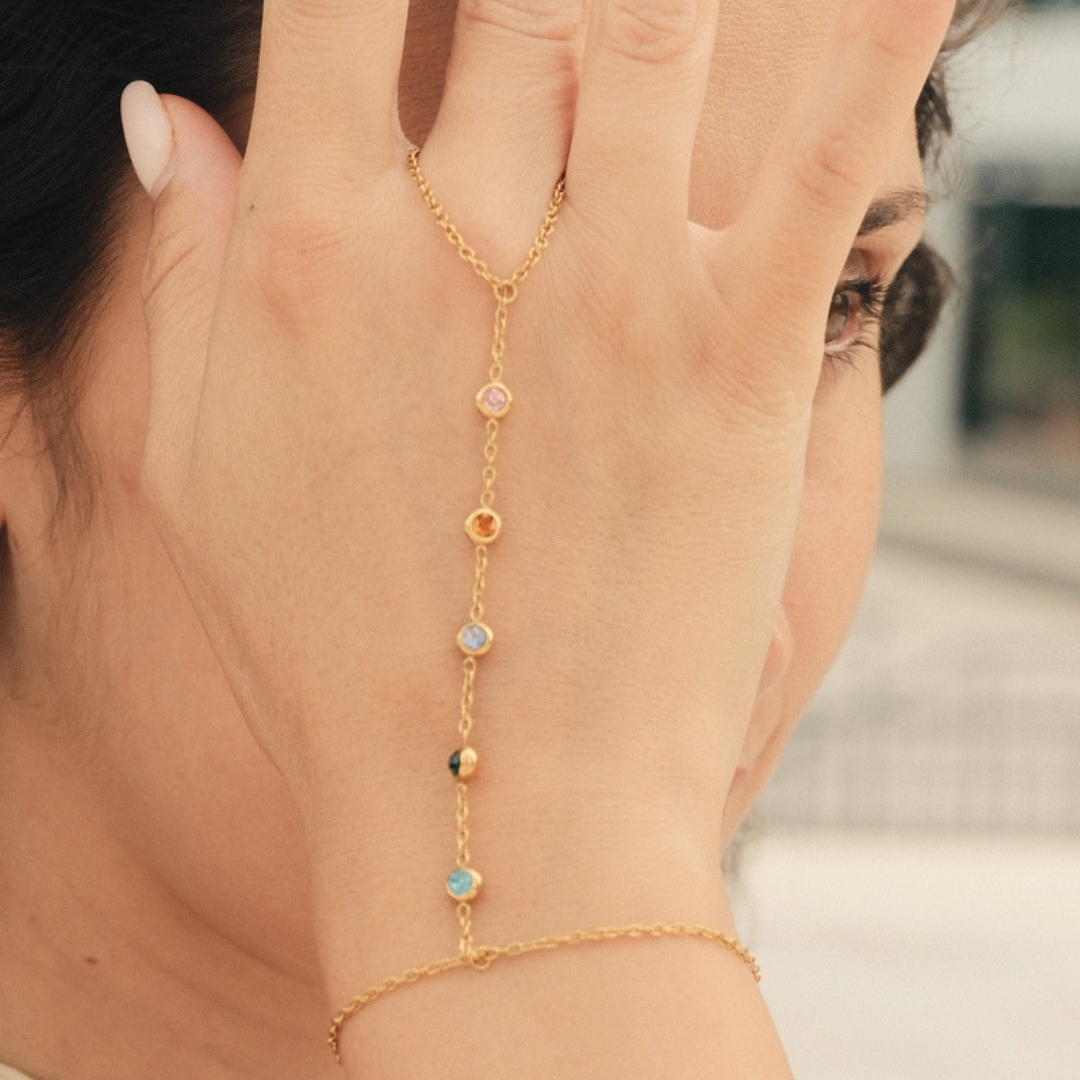 Bracciale dorato con catena sottile e pietre colorate a goccia