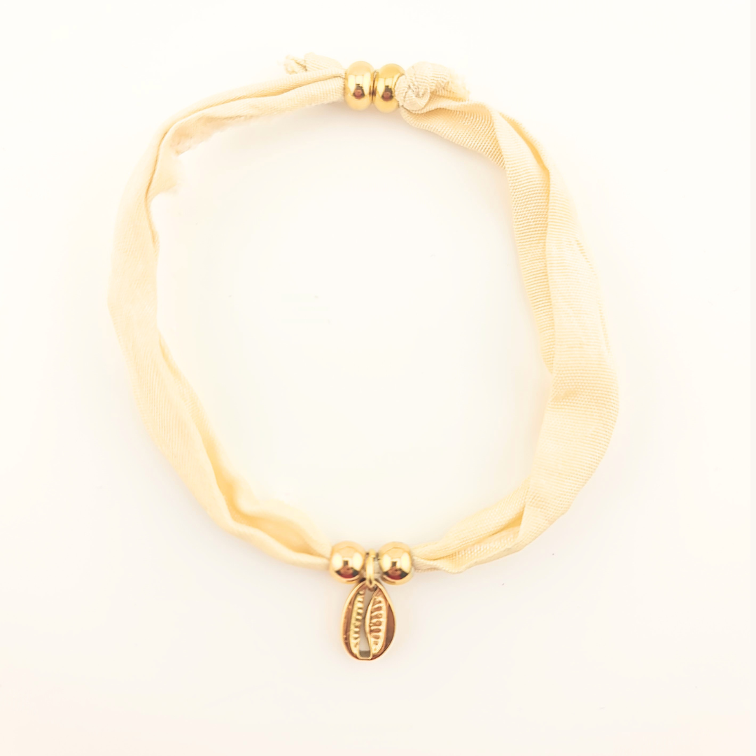 Bracciale in seta avorio con perle dorate e ciondolo a conchiglia.