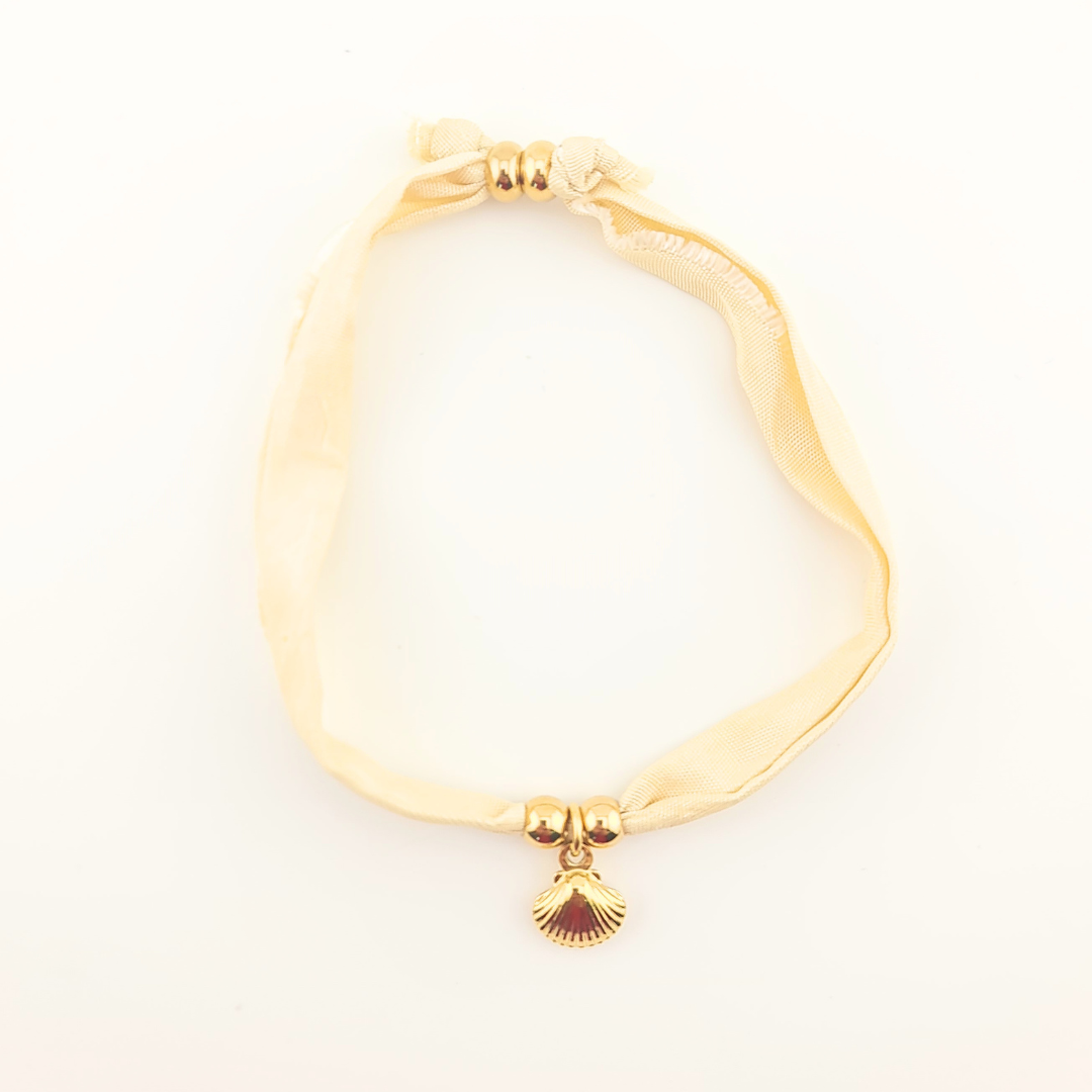 Bracciale in seta avorio con perle dorate e ciondolo a conchiglia.