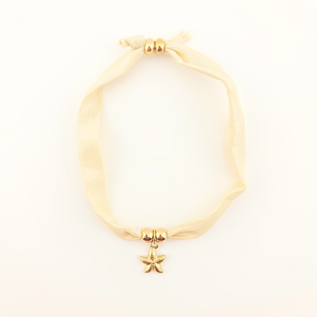 Bracciale in seta avorio con perle dorate e ciondolo a stella marina.