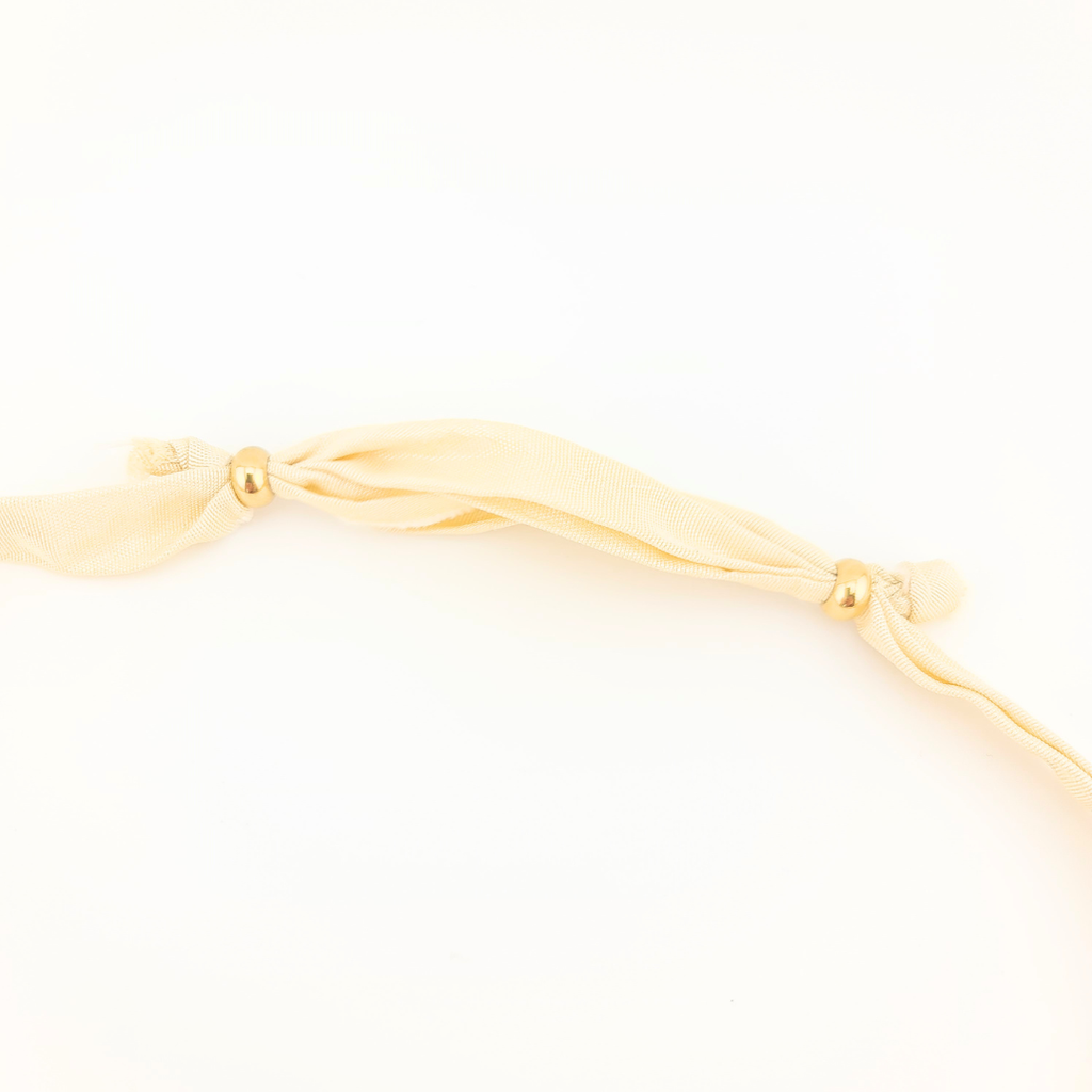 Collana: dettaglio del nastro di seta avorio e chiusura con perle dorate