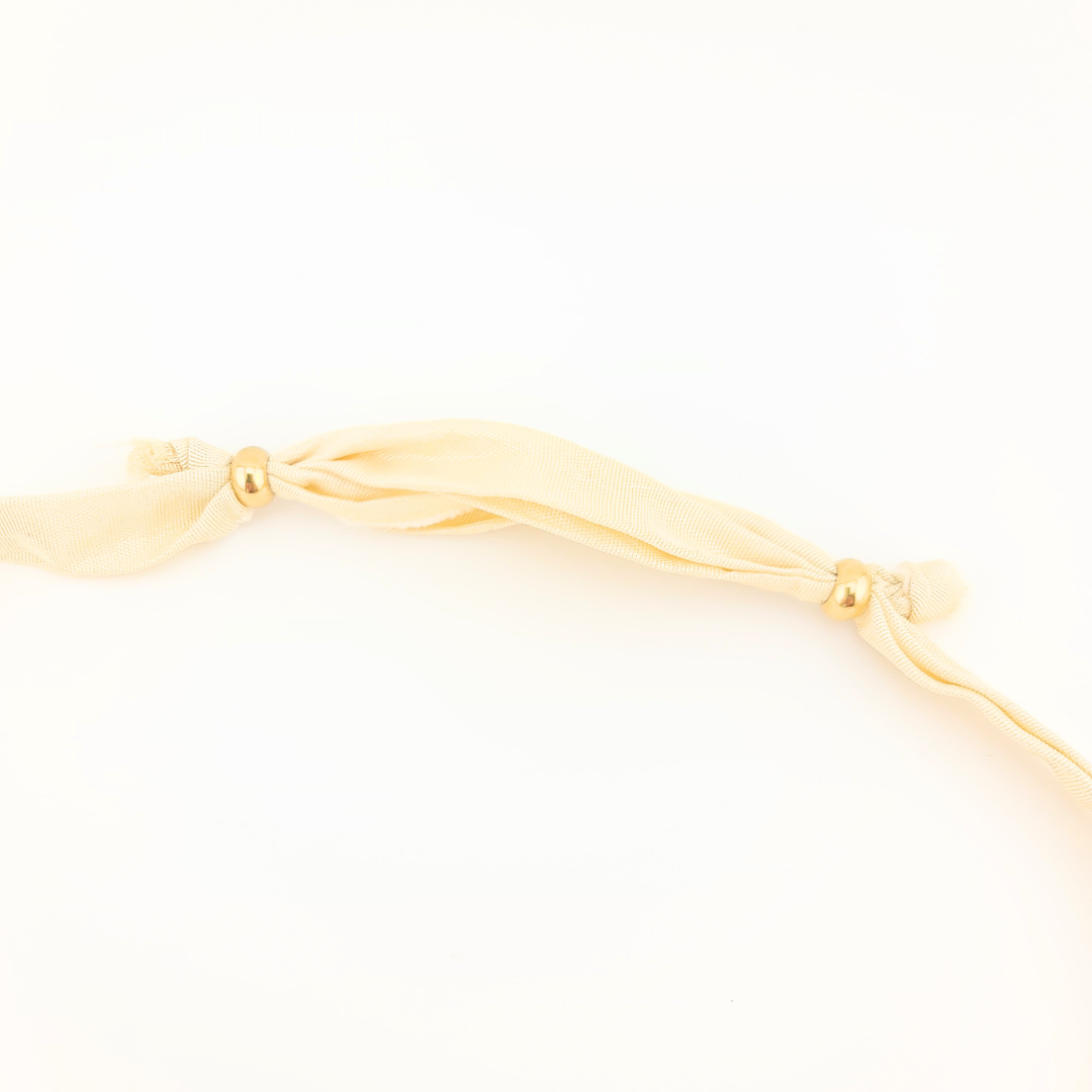 Collana: dettaglio del nastro di seta avorio e chiusura con perle dorate