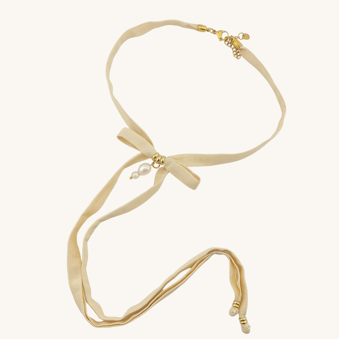 Scopri il choker "Perle di Mare": seta artigianale di San Leucio, fiocco elegante e perle luminose. Resistente all'acqua, anallergico e Made in Italy.