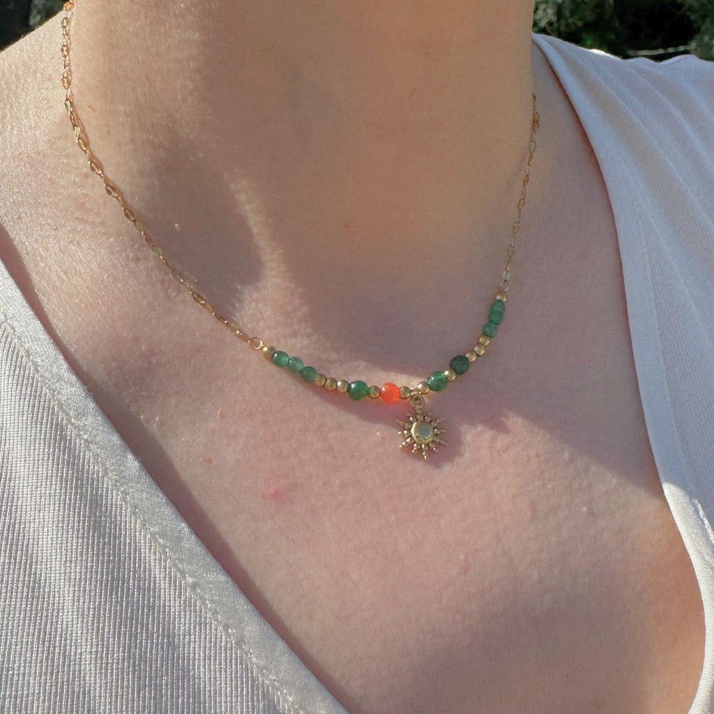 Collana in oro 18K con perle colorate e pendente sole, indossata al collo