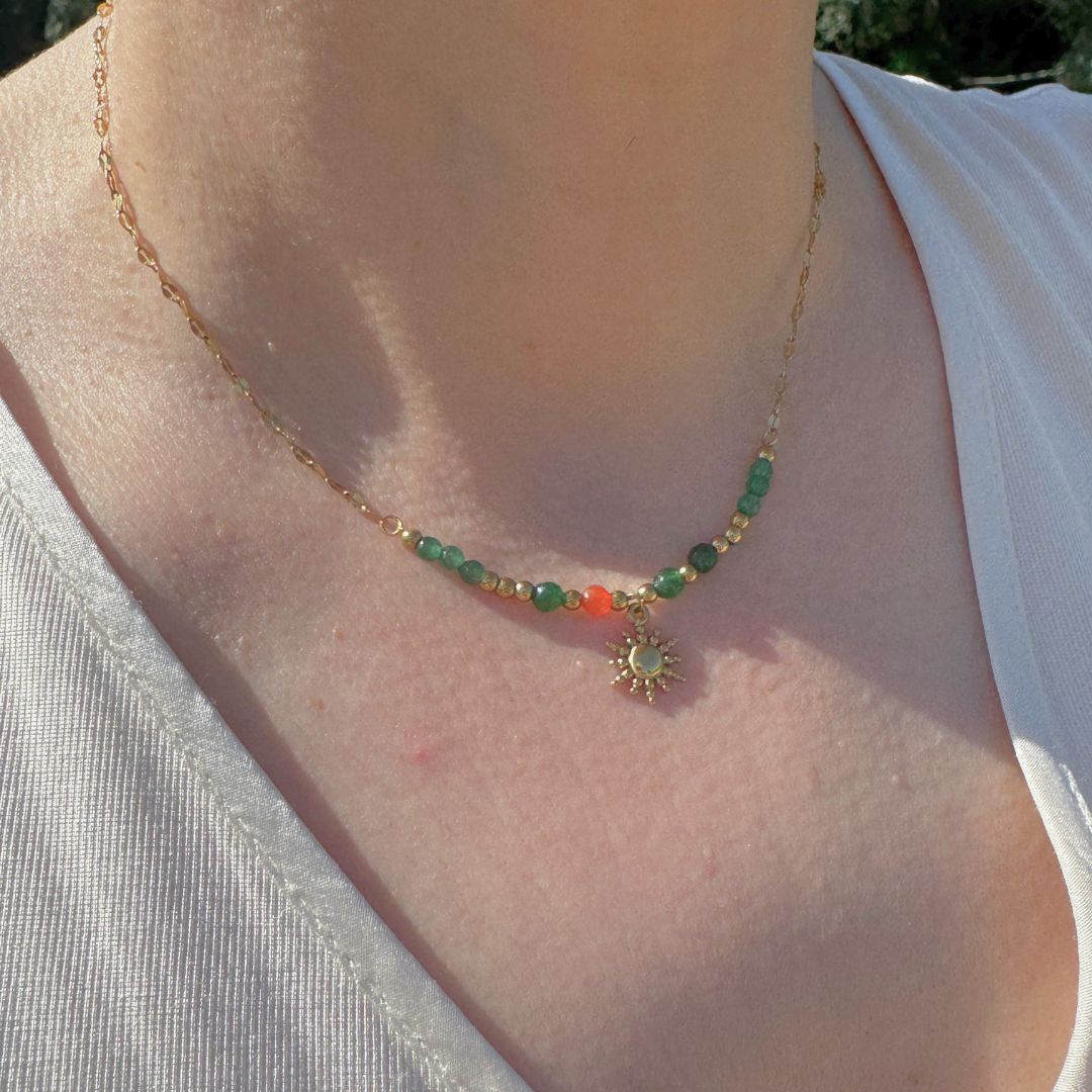 Collana in oro 18K con perle colorate e pendente sole, indossata al collo