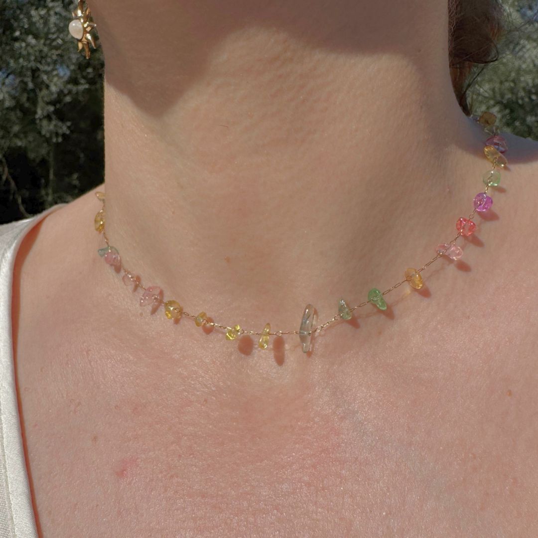 Collana in oro con pietre colorate multicolori sul collo