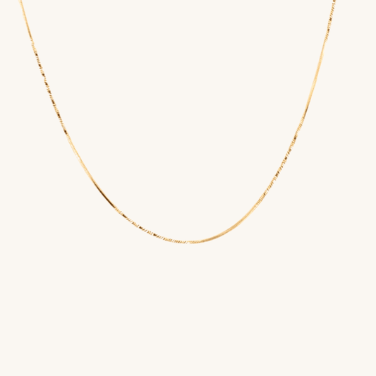 Collana piatta sottile oro 18k waterproof maglia silk touch indossata da modella Unique et Spécial