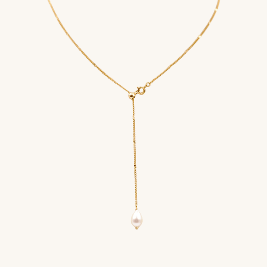 Collana a Y oro 18k waterproof con pendente perla a goccia su sfondo crema Unique et Spécial