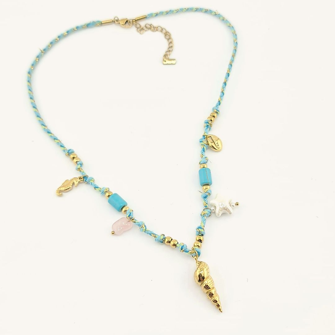 Collana in perline turchesi con ciondolo conchiglia dorato e charms pendenti.