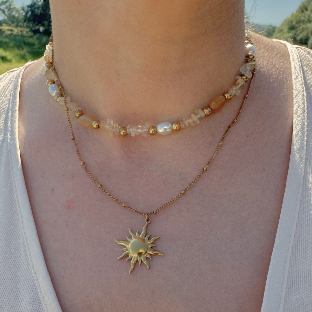 Collana doppia in oro 18K con perline multicolor e pendente sole sul collo