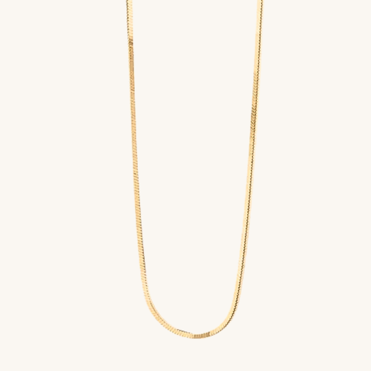 Collana oro 18k waterproof design organico con elementi scultorei su fondo crema Unique et Spécial