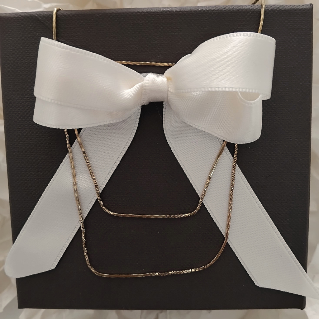 Collana oro 18K in confezione con scatola nera e fiocco bianco