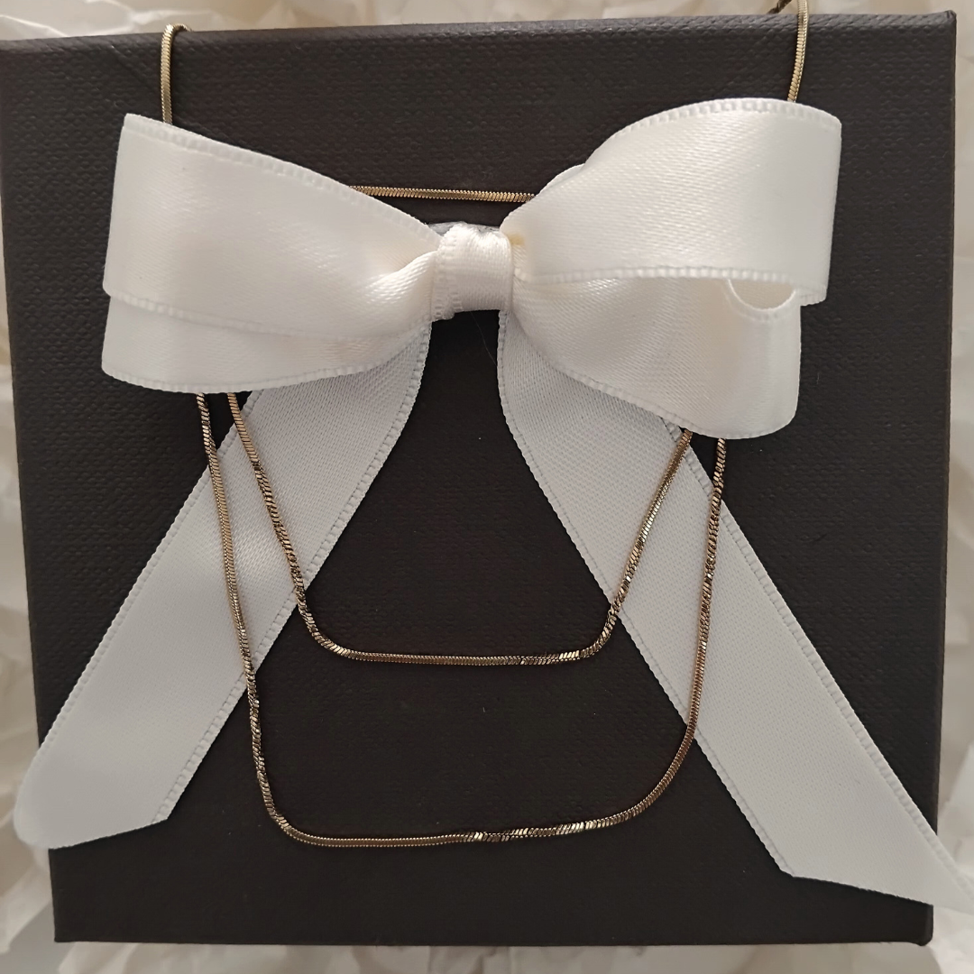 Collana oro 18K in confezione con scatola nera e fiocco bianco